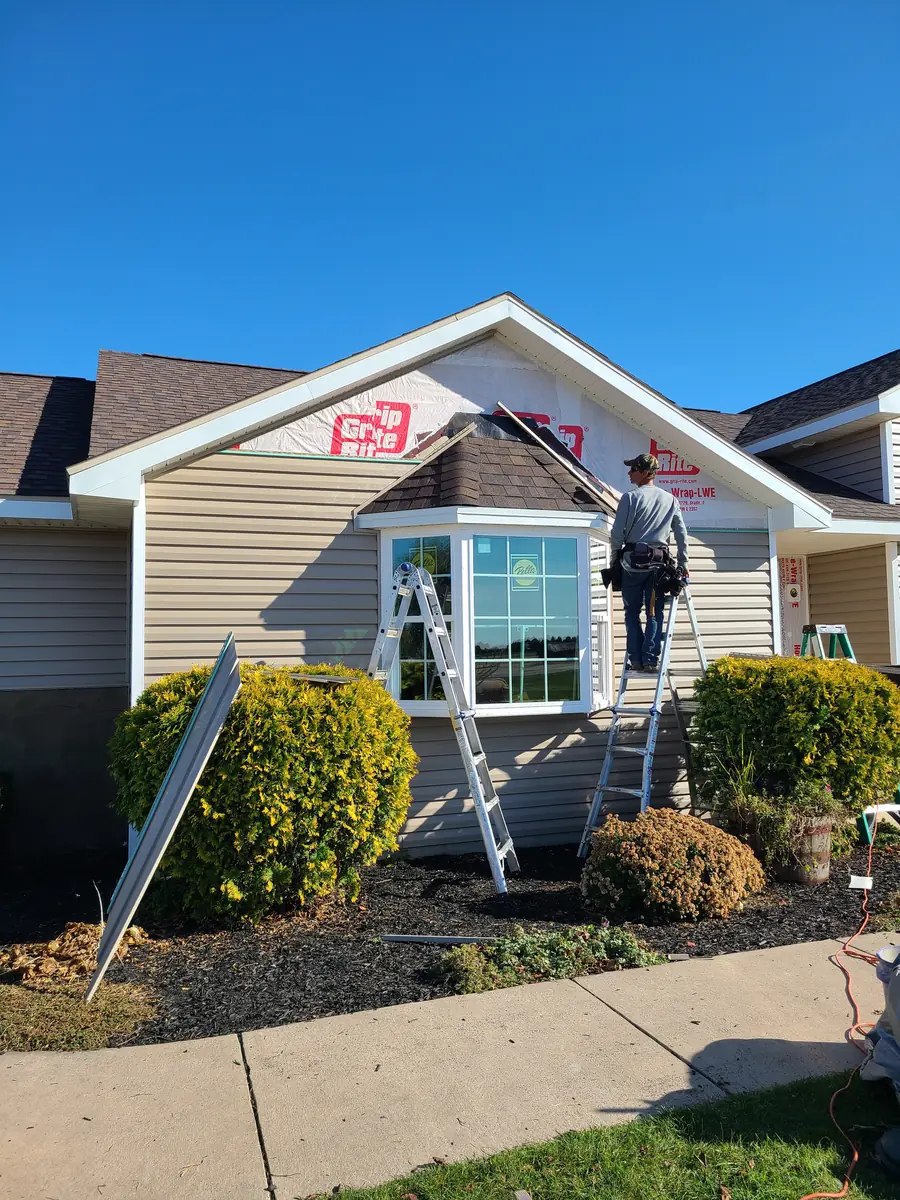 Siding installation underway around a new residential bay window