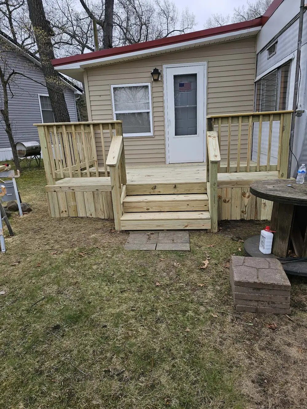 Completed pressure-treated wood entry porch with steps and railings