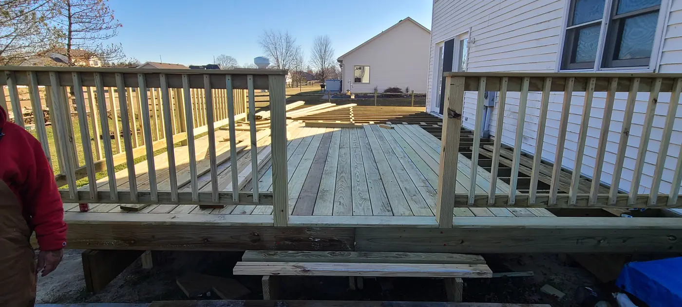 Deck boards and railings being installed during a residential deck rebuild