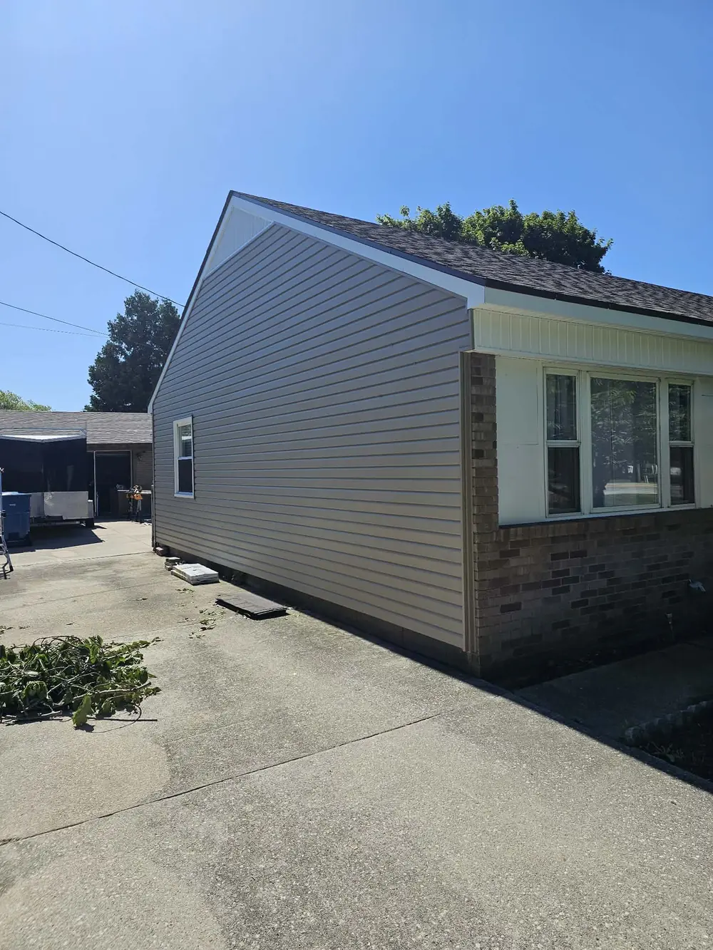Completed tan vinyl siding installation on a residential home
